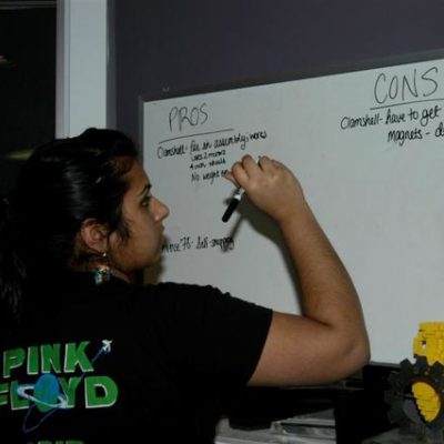 Meera N. recording the pros and cons from the minibot design discussion.